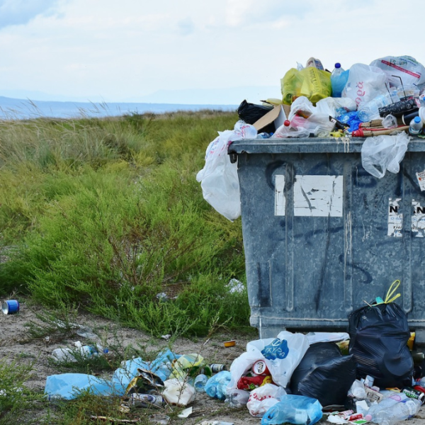 A bin full of rubbish in the countryside