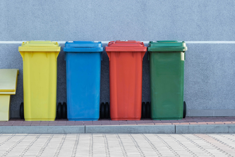 A row of recycling bins on a pavement